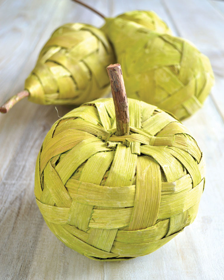 Homemade basket woven pumpkins in a light yellow-green color arranged in a group of three. 