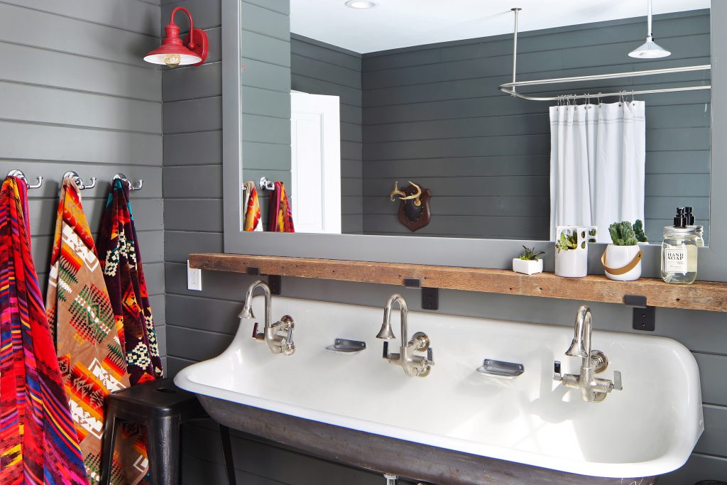 Shiplapped bathroom walls in a shade of gray with a salvaged sink and a custom ledge above the sink that was reclaimed.