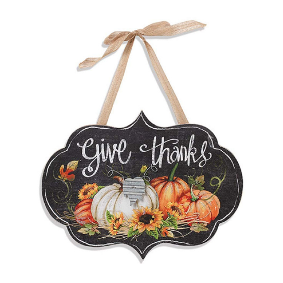 Rustic wall hanging with a fall pumpkin and sunflower image and "give thanks" in chalk cursive with a ribbon tie.