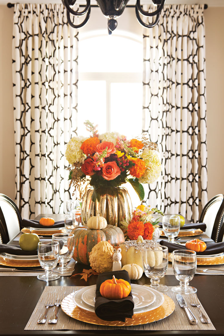 Halloween dinner party set for 5 guests with pumpkins, gourds and a large floral arrangement as the centerpiece of the tablescape. 