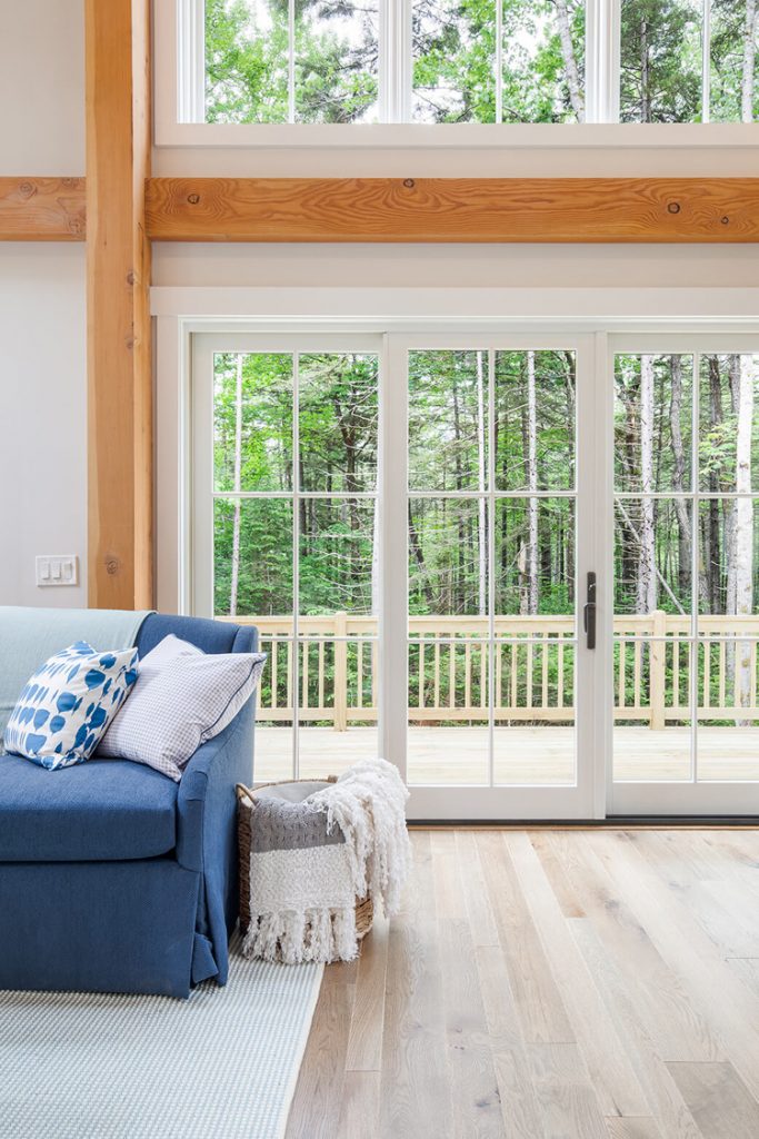 This living room has large windows and glass door that show how natural light makes white paint look lighter and brighter.