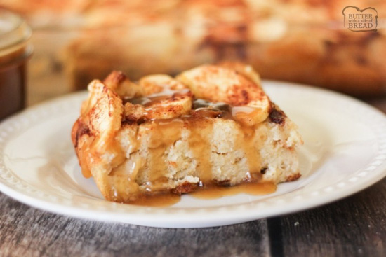 White glass plate with a generous serving of apple bread pudding with a caramel sauce topping. 