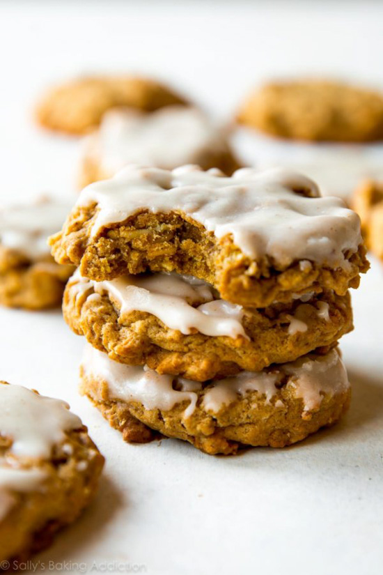 Stack of cookies, with cream y icing and the top cookie has a bite taken out of it. 