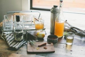 A fall cocktail creation station on a counter backlit by a window.