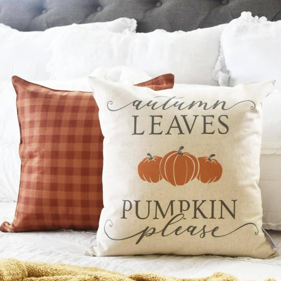 Fall finds these pillow covers displayed on a white and gray bed, one in orange gingham and one says', 'autumn leaves and pumpkin please'. 