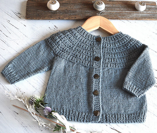 Gray button-down knit cardigan for a child, on a wooden hanger. 