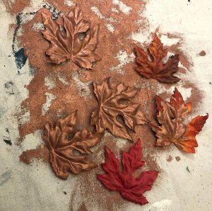 Copper painted fall maple leaves on a dropcloth