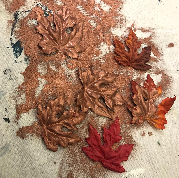 Copper painted fall maple leaves on a dropcloth