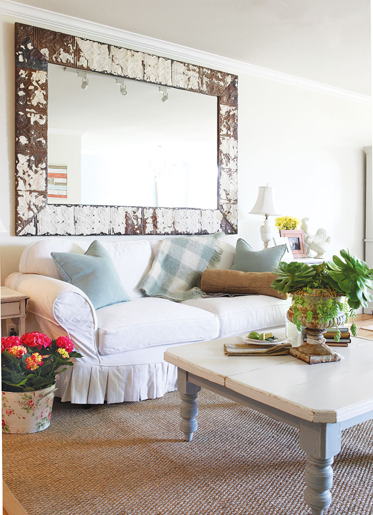 English Country style living room with cozy oversized white couch and white wooden coffee table. 