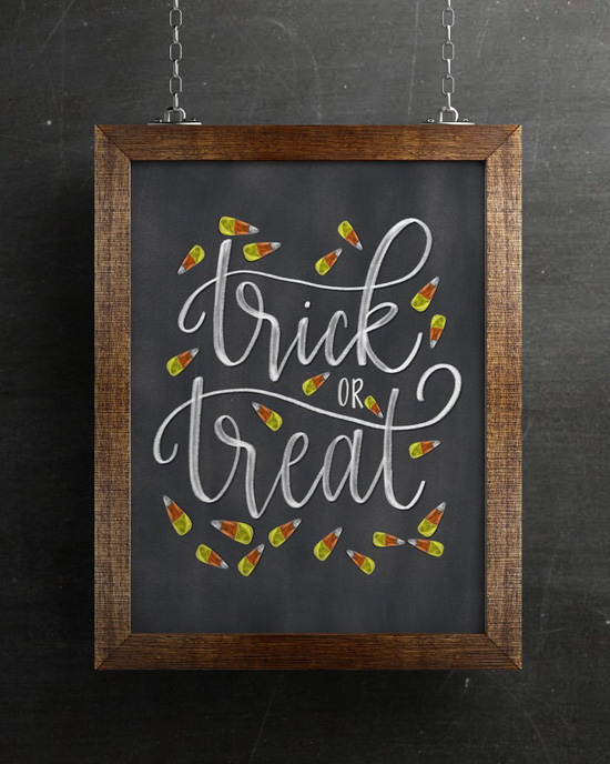 Wooden framed chalkboard with "trick or Treat" hand-lettered and drawn candy corns on it. 