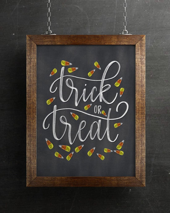 Wooden framed chalkboard with "trick or Treat" hand-lettered and drawn candy corns on it.