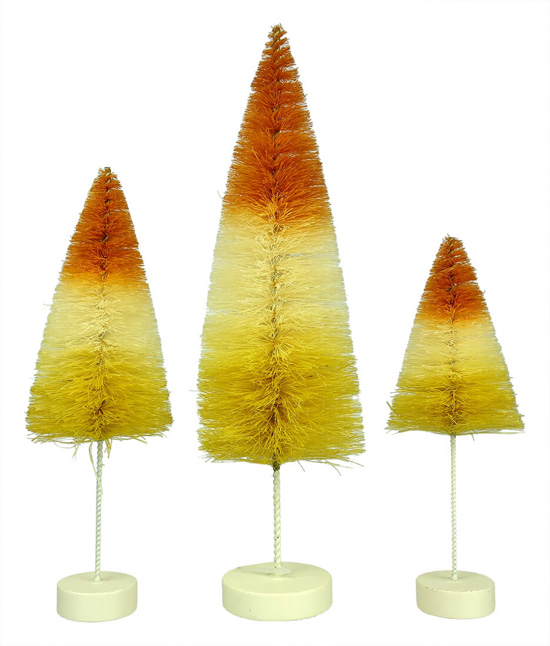 A set of three tall and thin bottle brush trees colored to look like candy corns. 