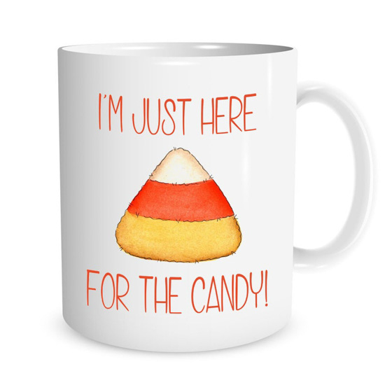 White ceramic mug with "I'm just here for the candy" and a cartoon candy corn in the center.