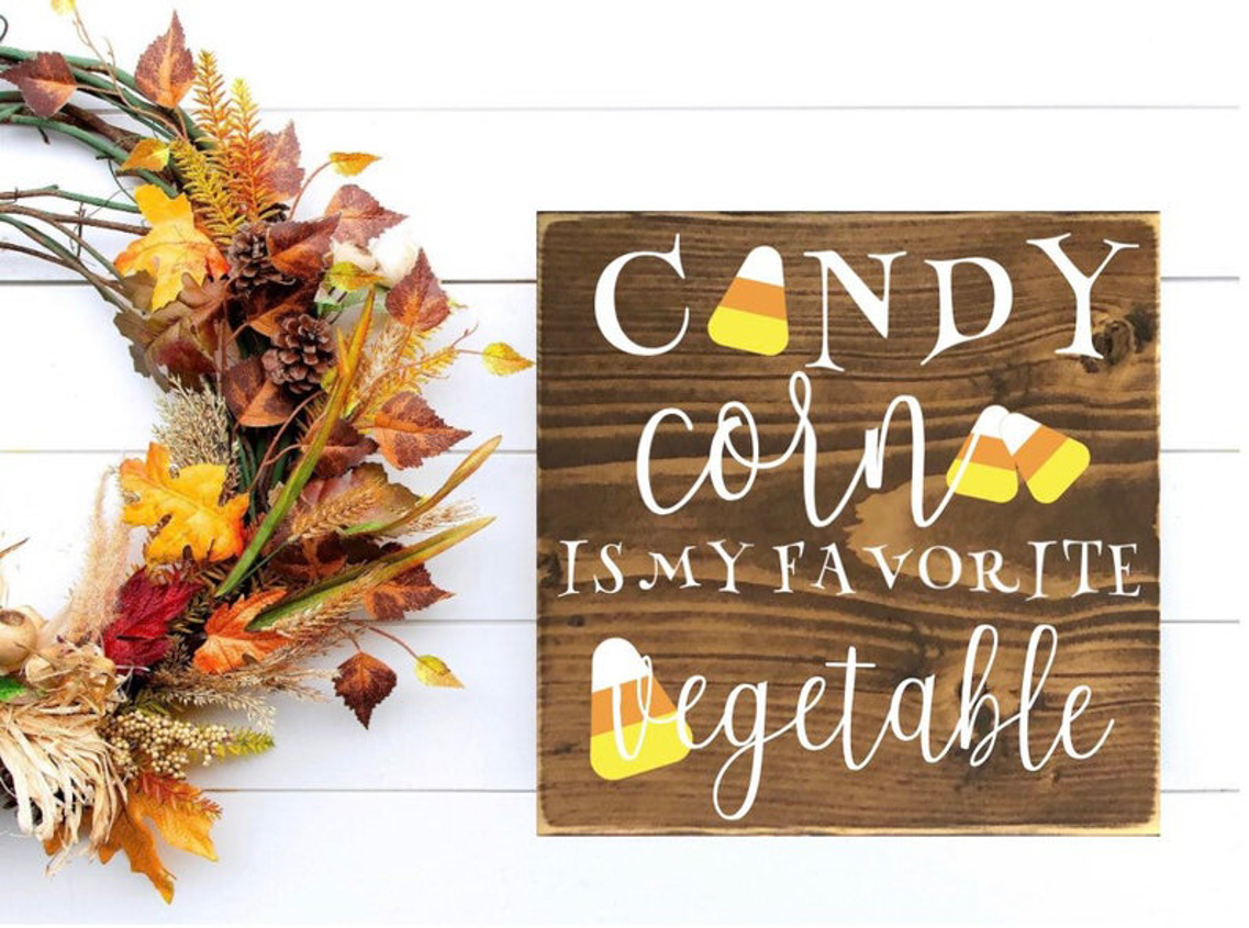 Fall wreath and a wooden home decor sign that states, "candy corn is my favorite vegetable."