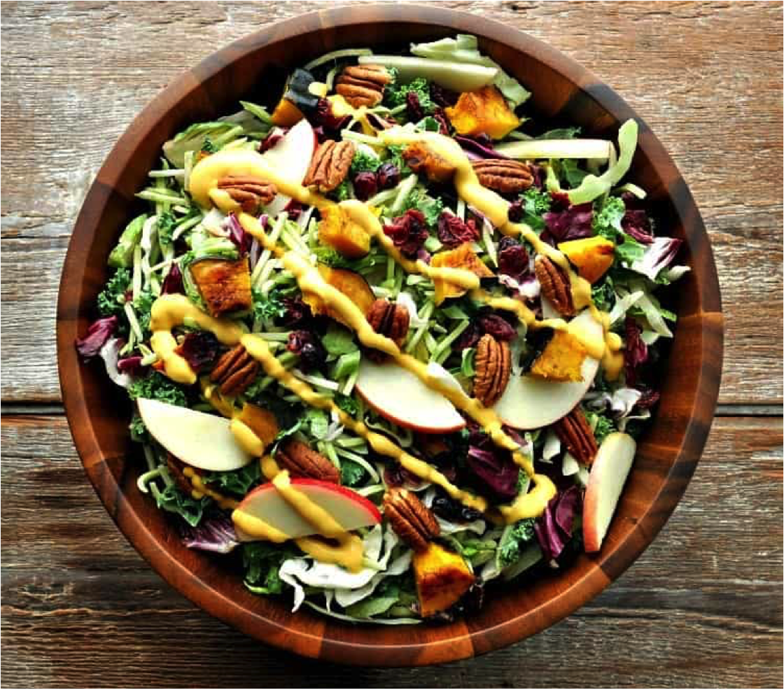 Fall Harvest Salad with Pumpkin Goddess Dressing in a wooden bowl