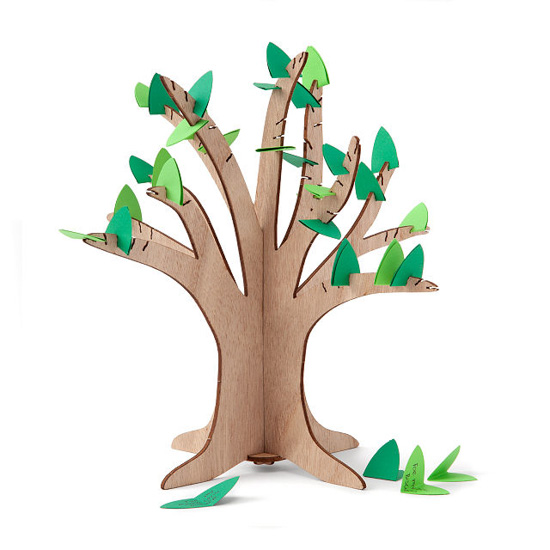 Small standing wooden tree with small slits for finding slips of green paper in them to make leaves. 