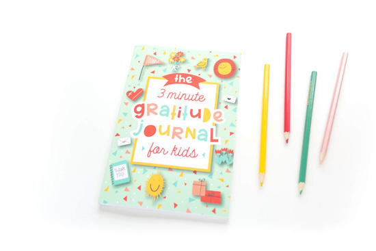 3 minute gratitude journal for kids next to 4 colored pencils that match the book's color scheme.