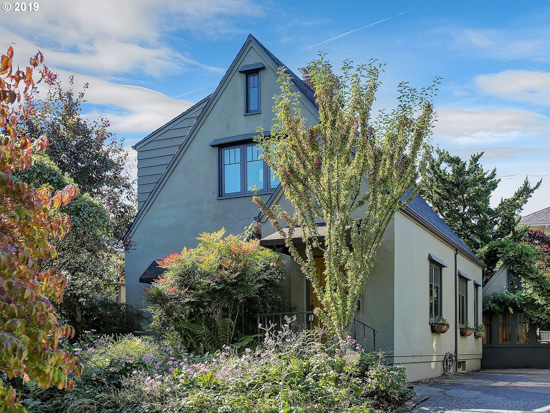 Overgrown greenery surrounding a charming storybook cottage in Portland, Oregon.