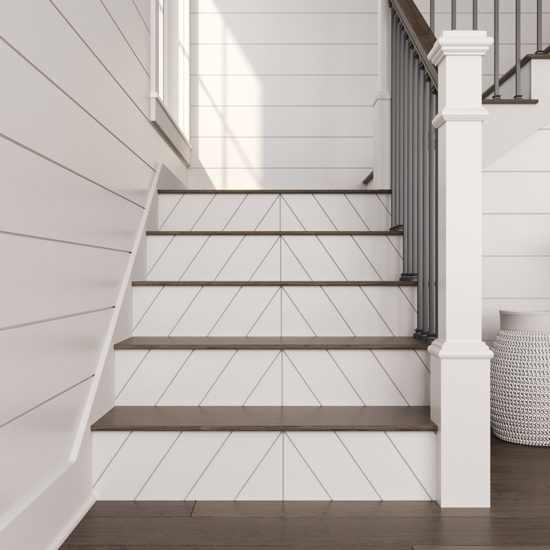 View from the bottom of a staircase displaying new white shiplap stair risers. 