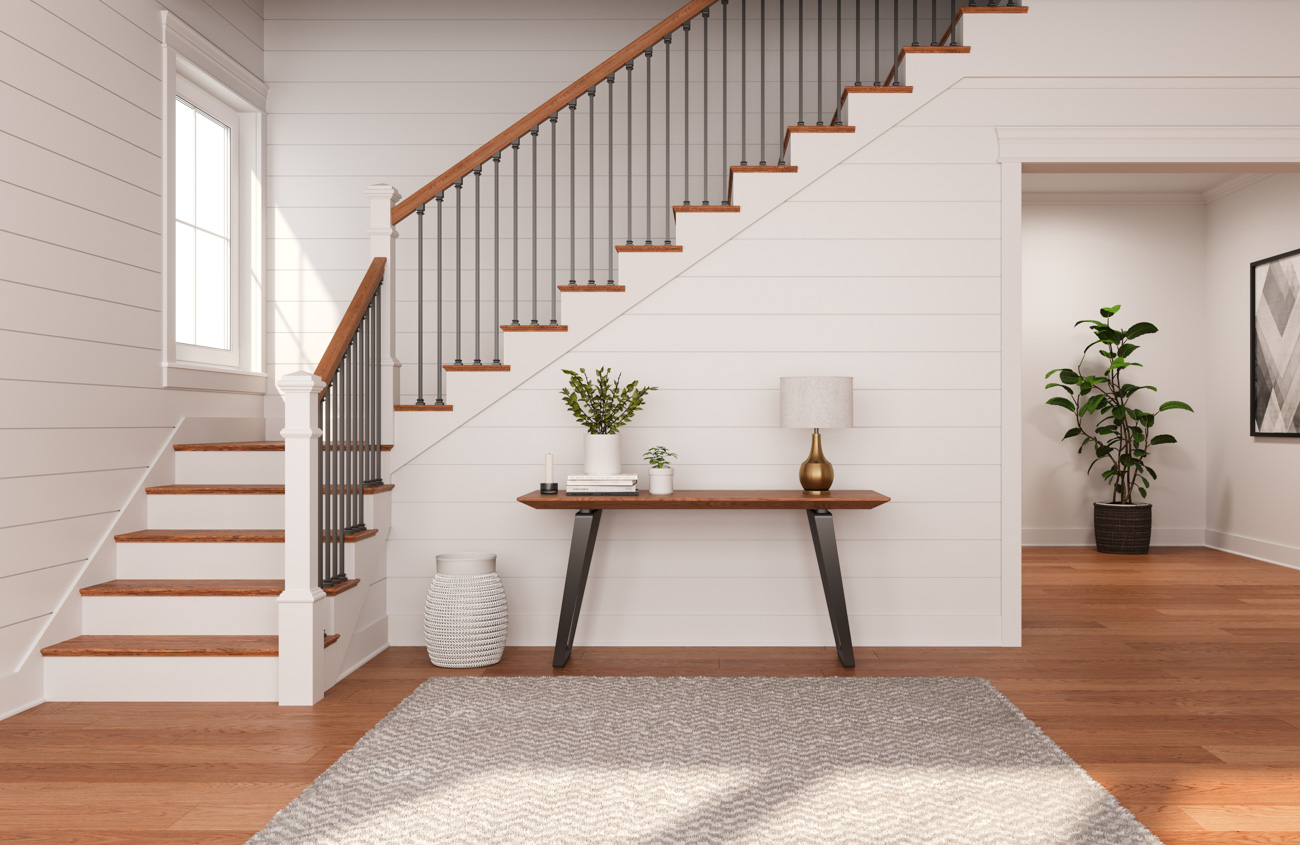 Warm hardwood floors leading to a staircase displaying fresh white stair risers that bend up towards the second story.