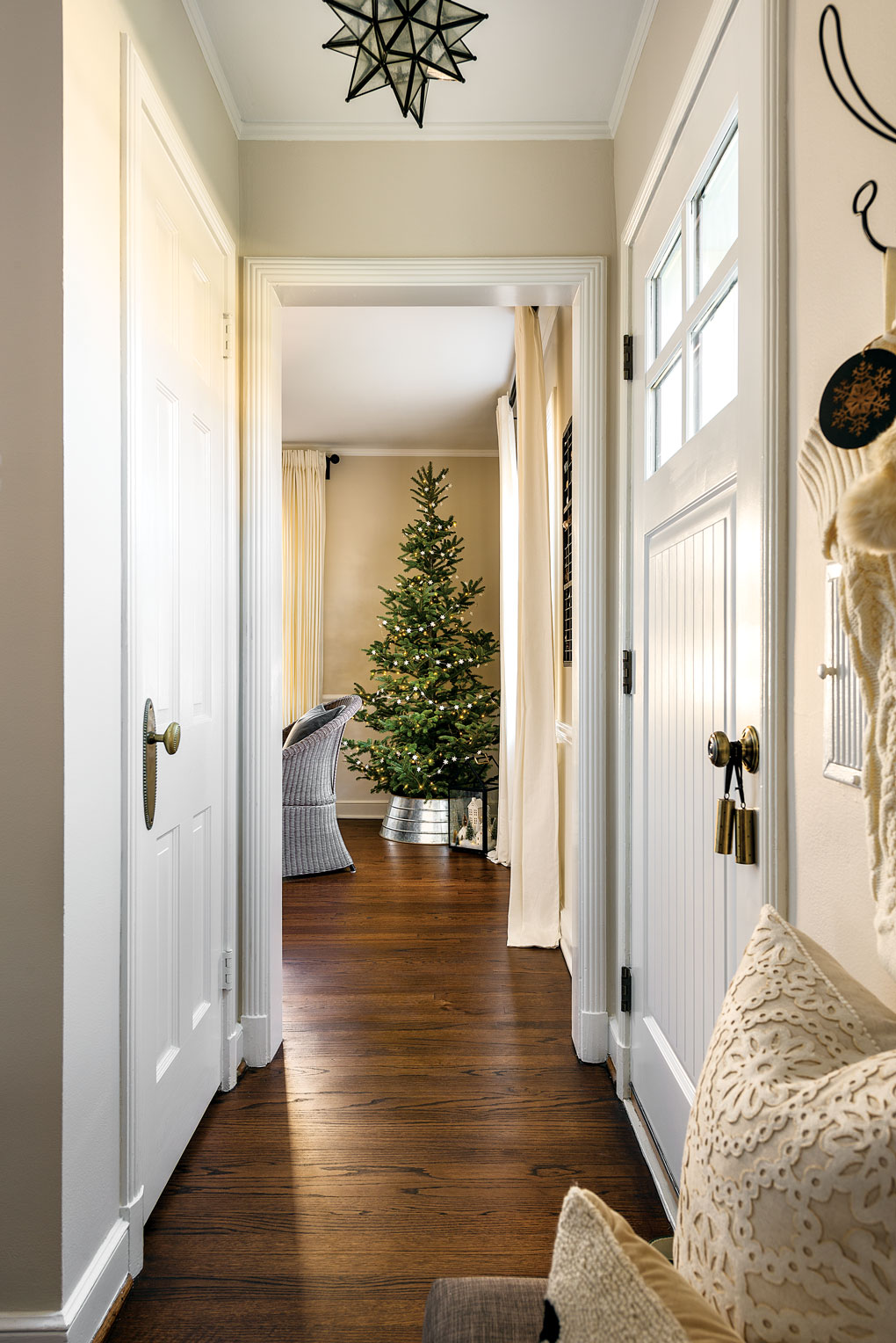 Farmhouse styled hallway looking down at the Christmas tree passed the front door. 