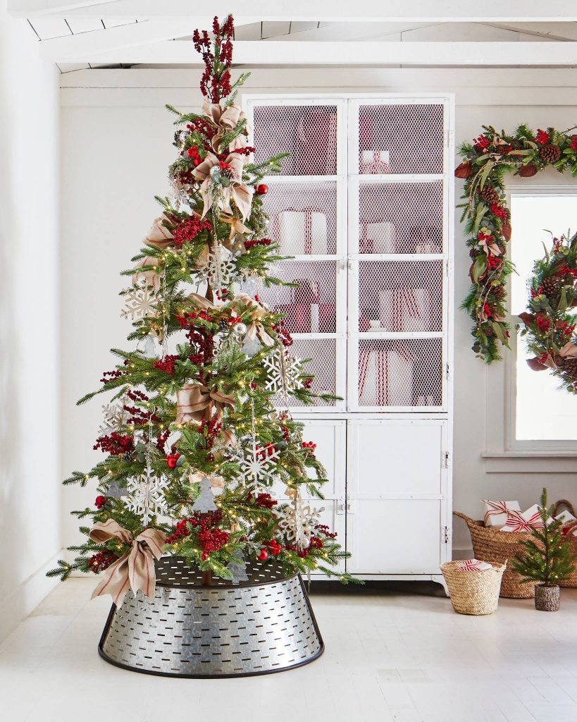 This Alpine balsam fir style tree from Balsam Hill in a white room near a white farmstyle cabinet