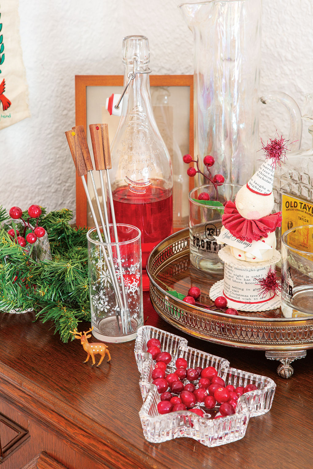 A vintage inspired drink station, decanters, stir sticks and a crystal candy dish with red candies.