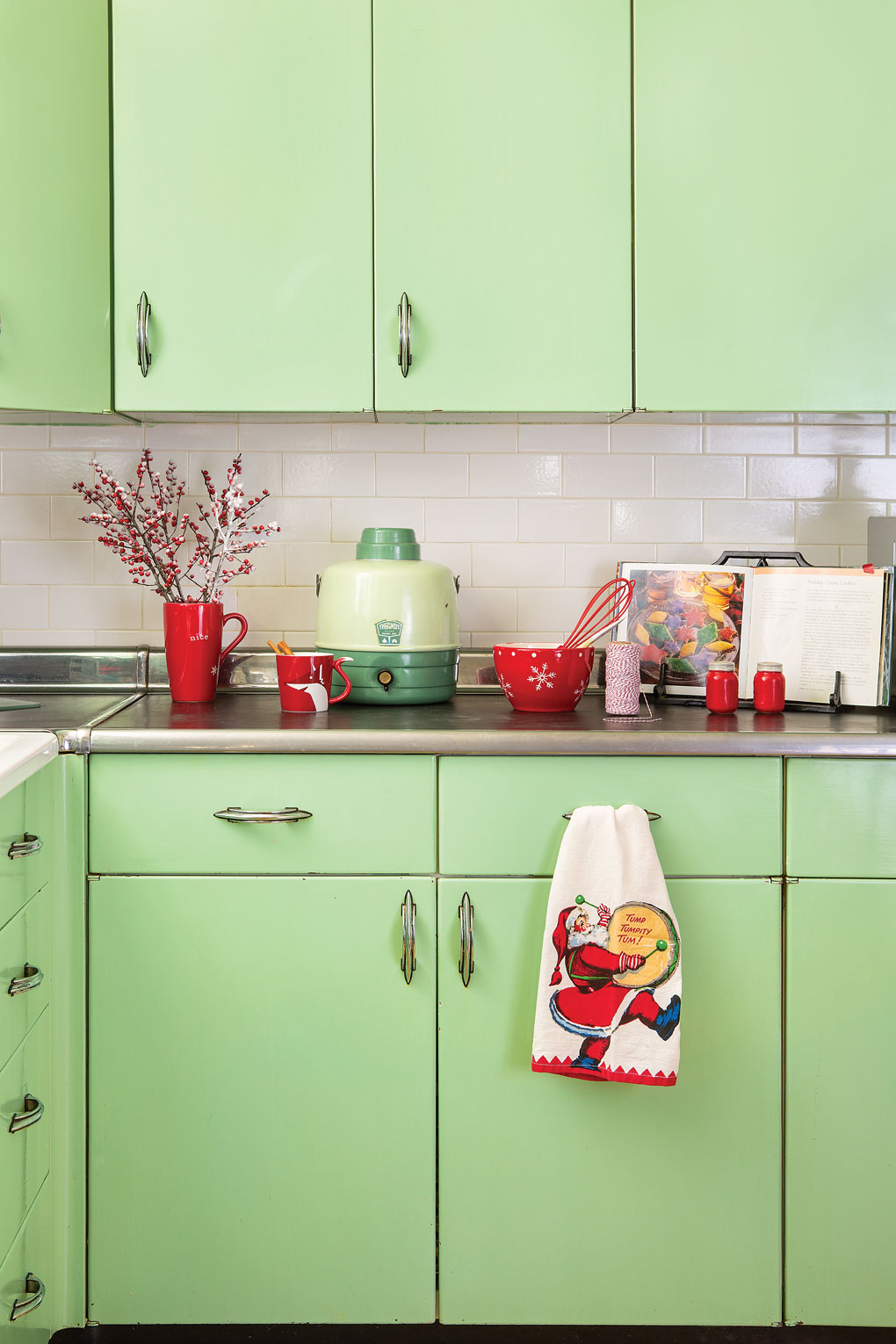 1950s steel Youngstown kitchen cabinets in mint green with vintage accessories arranged on the countertop.