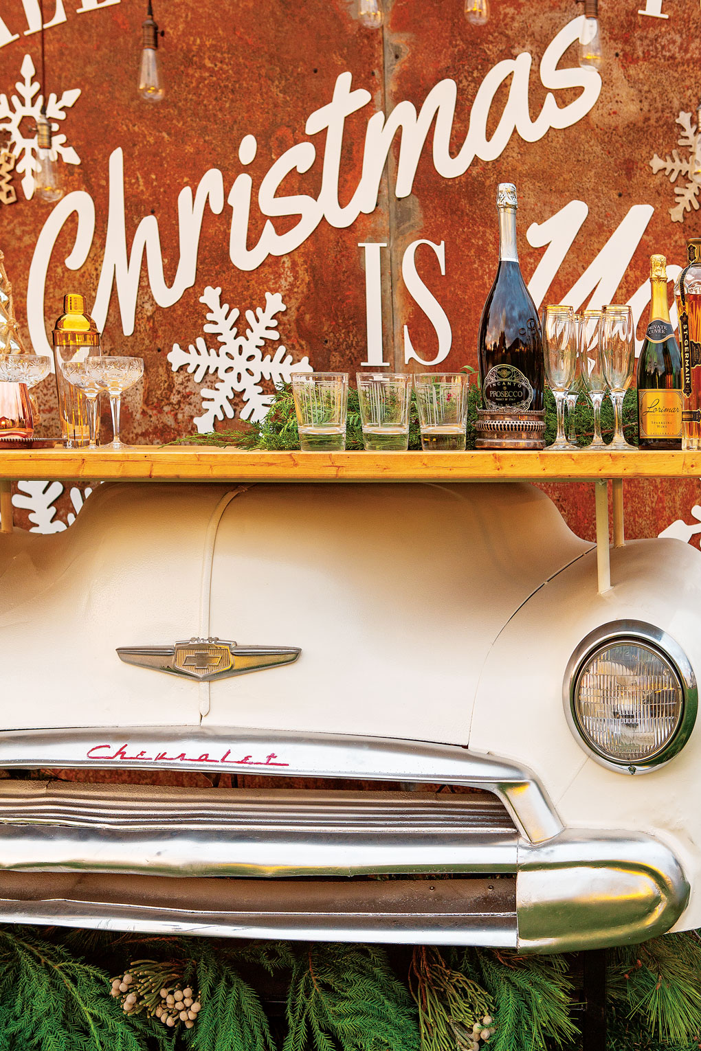 A white, genuine front end of a 1949 Chevy crafted into a barnyard bar display topped with champagne, drinks and glasses. 