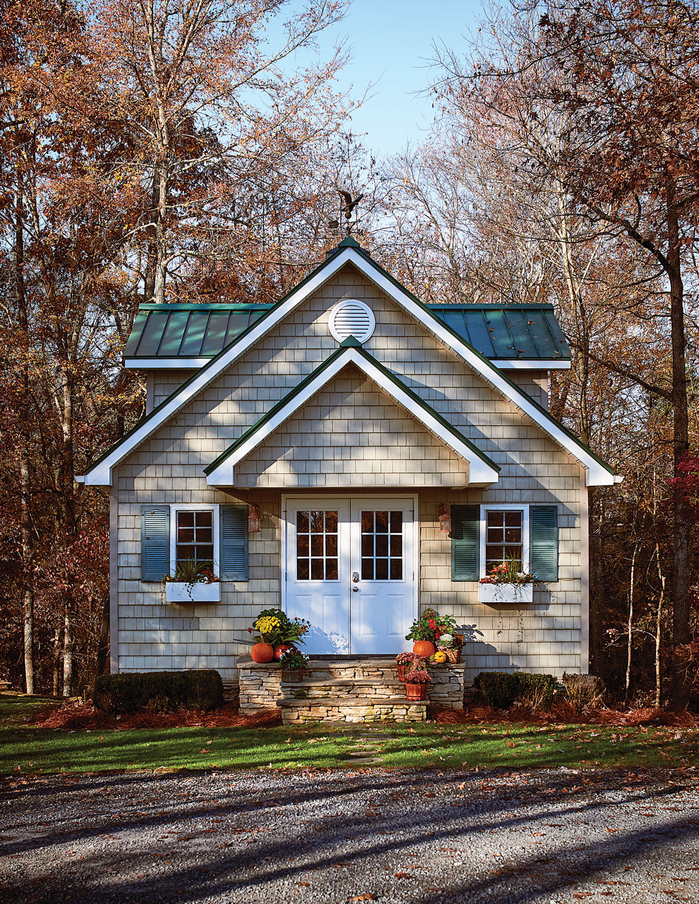 Exterior view of a cottage styled shed in the woods. 