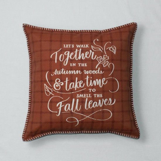 Auburn colored throw pillow with a fall quote written on one side in white. 