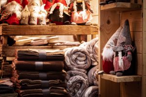 wool toys and a stack of wool blankets at a christmas market at night