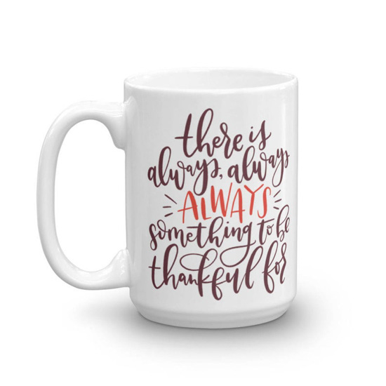 White, porcelain mug with hand lettering that says "there is always something to be thankful for".
