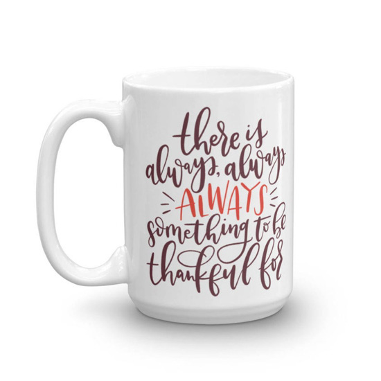 White, porcelain mug with hand lettering that says "there is always something to be thankful for". 