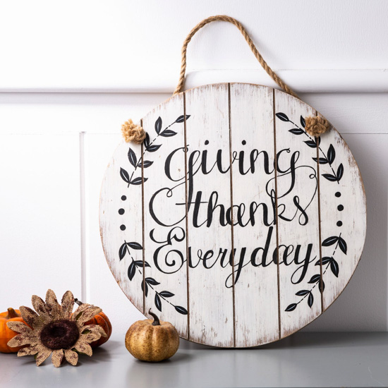 Round wooden sign with a rope loop for hanging that says "giving thanks everyday."