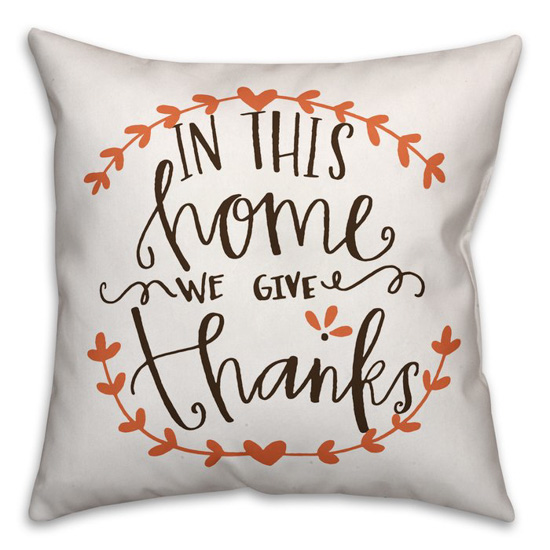 White throw pillow, handwritten saying "in this home we give thanks". 