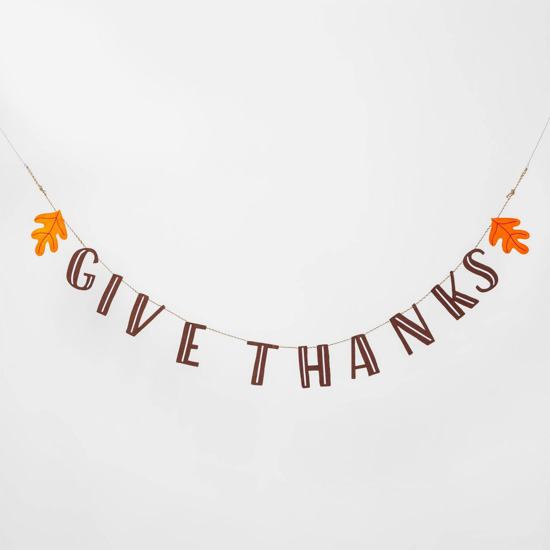 Simple banner that says "give thanks" bookended by orange fall leaves.