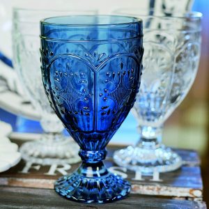 Blue glass goblet with lighter glass goblets in the background.