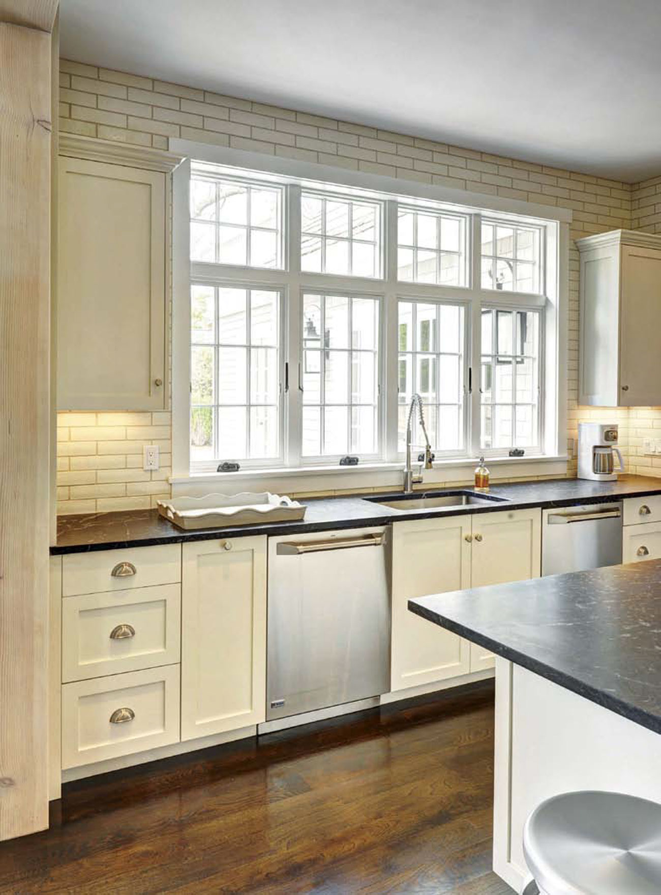 Photo of a kitchen over the island toward the kitchen sink and windows for a gorgeous view. 