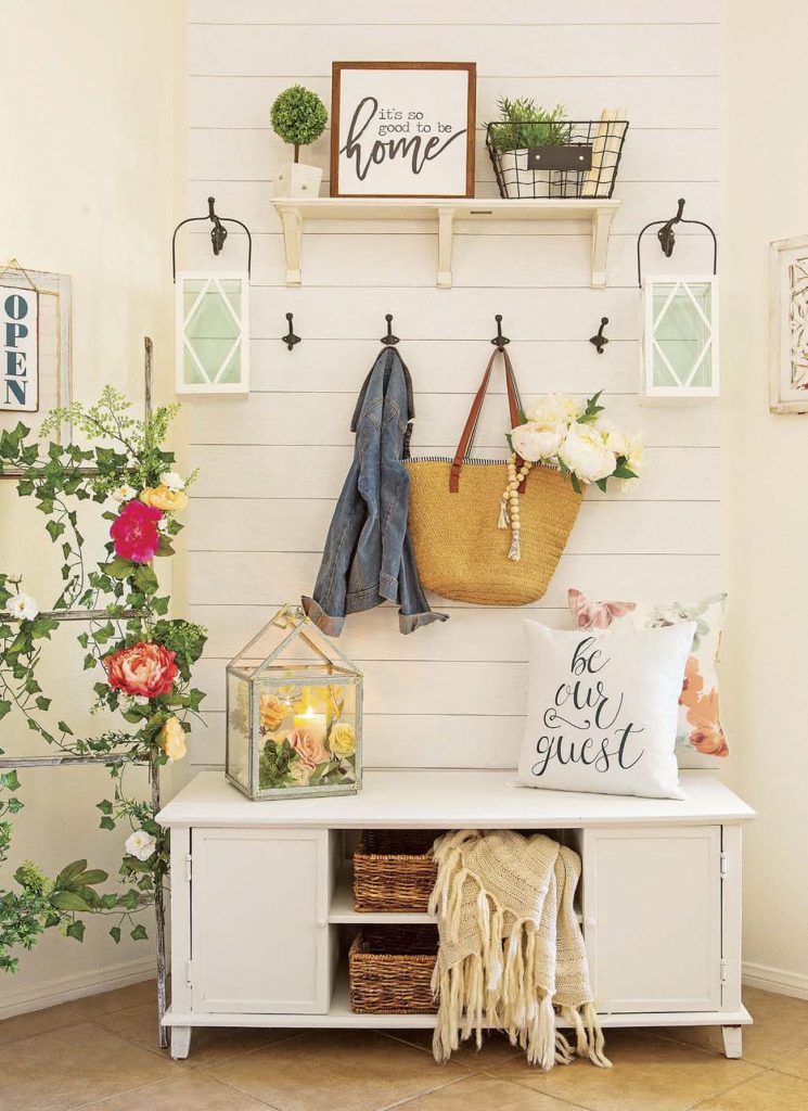 Custom shiplap up the wall behind a bench to create a faux entryway with hooks for purses and jackets.