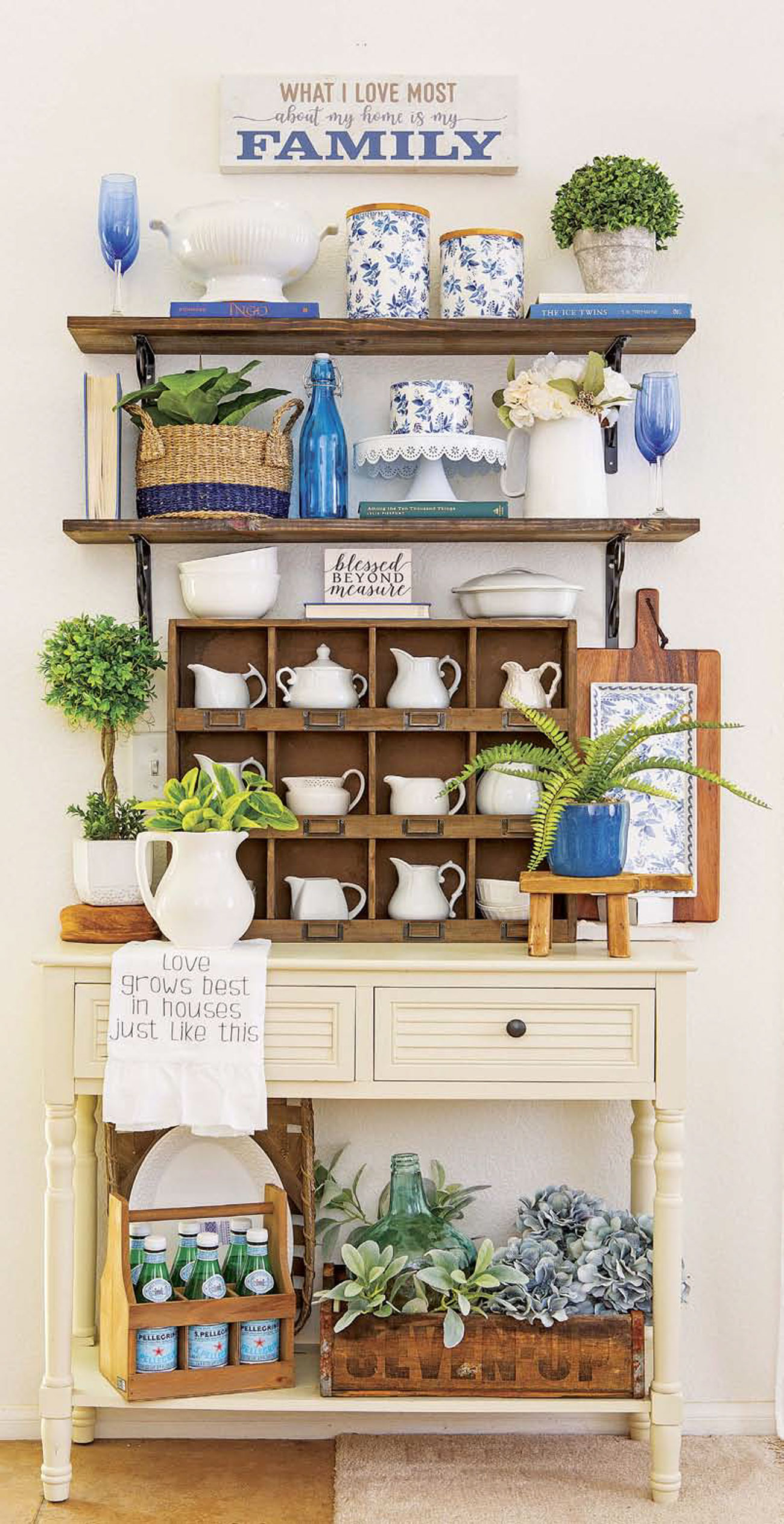 Wooden shelving and a vintage cubby cabinet filled with white cream-and-sugar sets and pops of blue and green. 