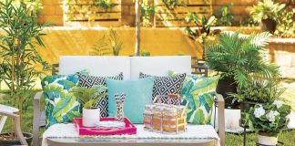 Outdoor seating area with turquoise accents and drink station as well as rustic lanterns.
