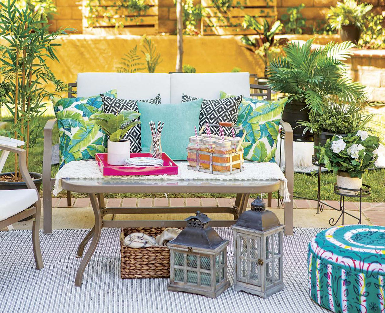 Outdoor seating area with turquoise accents and drink station as well as rustic lanterns.