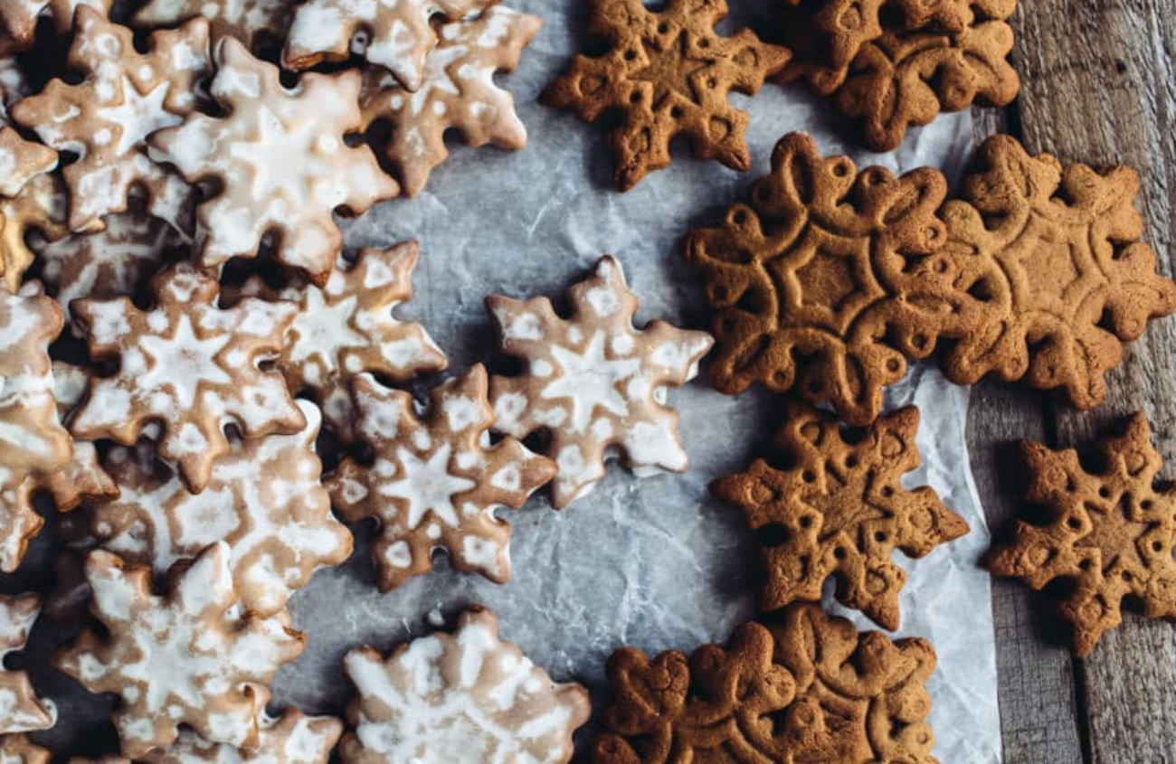 Snowflake shaped gingerbread cookies in different sizes and some with white glaze on top.