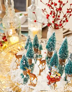 christmas vignette of mini bottle brush trees and deer on a crystal cakeplate