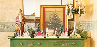 green antique sideboard with christmas collectibles displayed on top