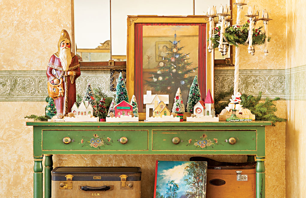 green antique sideboard with christmas collectibles displayed on top