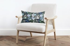 modern white and tan armchair with a blue floral pillow.