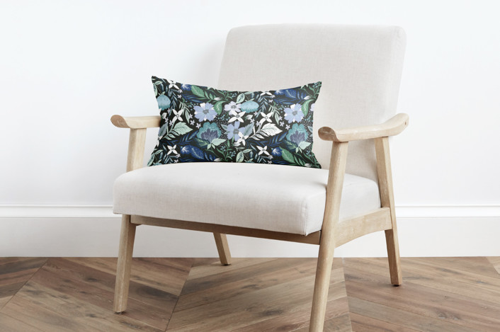 modern white and tan armchair with a blue floral pillow. 