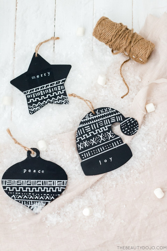 Homemade Mud cloth style ornaments in the shape of an ornament, star and winter hat, hung on pieces of twine. 